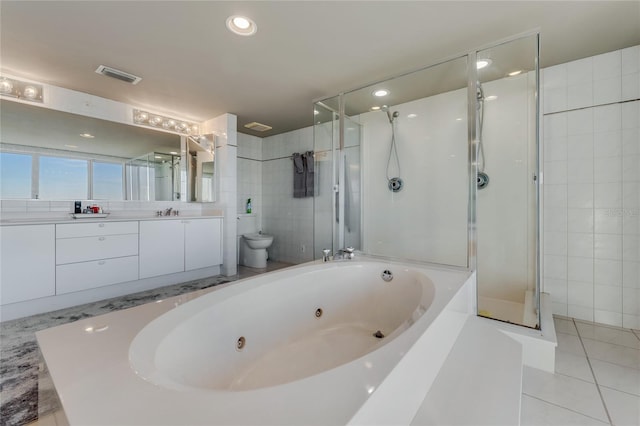 bathroom featuring vanity, tile walls, tile patterned floors, a tub with jets, and a stall shower