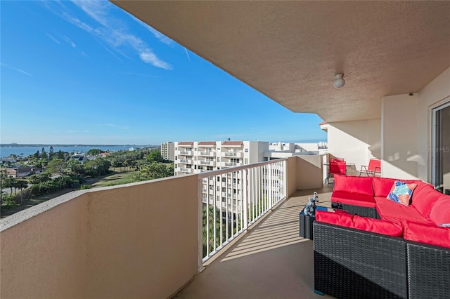 balcony with a water view and an outdoor hangout area