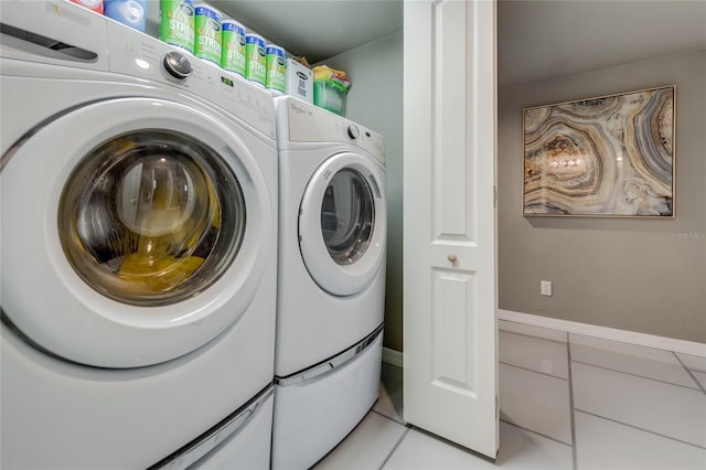 clothes washing area featuring laundry area, separate washer and dryer, and light tile patterned flooring