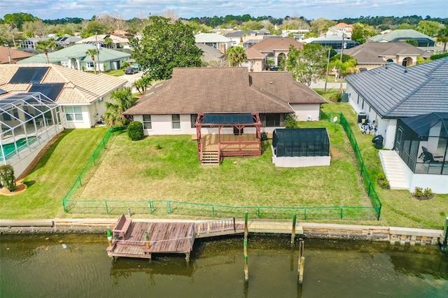 back of property with a lanai, a residential view, a deck with water view, and a gazebo