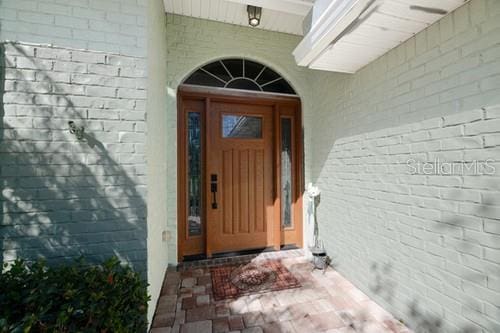 entrance to property featuring brick siding