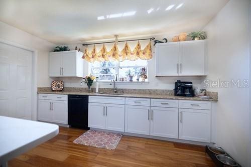 kitchen featuring dark wood-style flooring, white cabinetry, a sink, and dishwasher