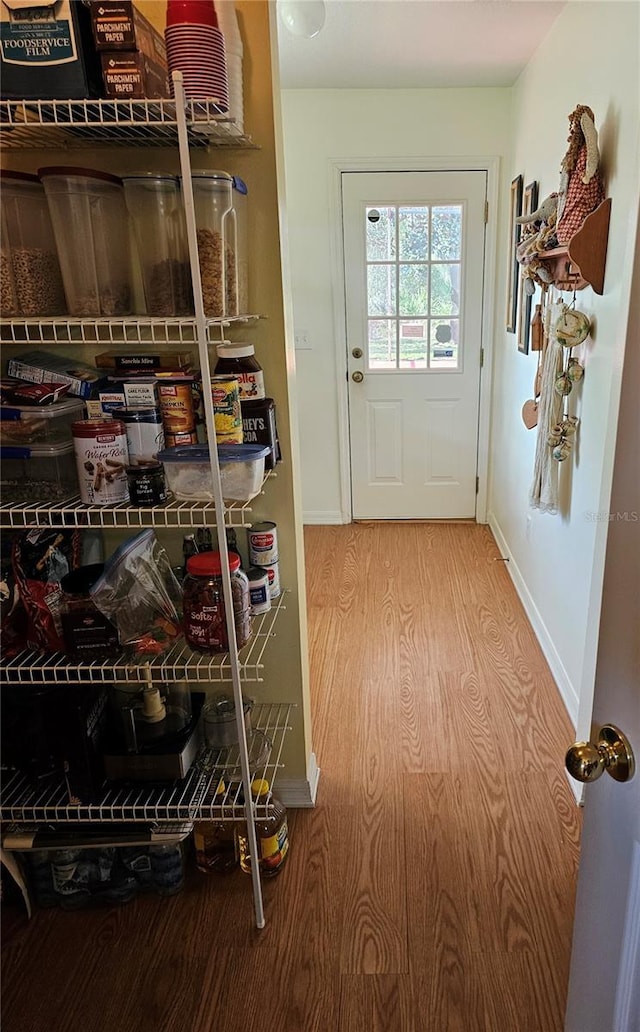 doorway to outside with wood finished floors and baseboards