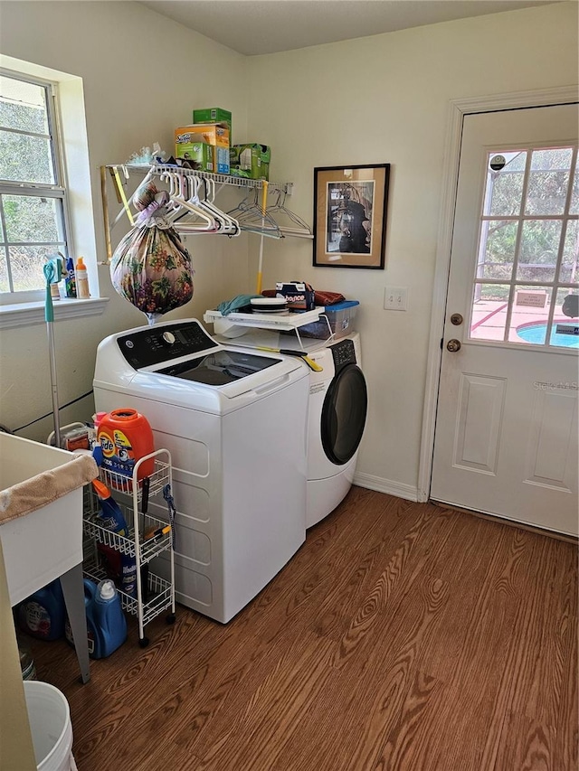 laundry room with laundry area, wood finished floors, and washing machine and clothes dryer