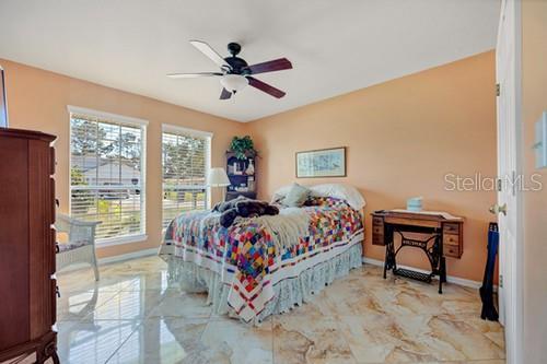 bedroom featuring marble finish floor, baseboards, and a ceiling fan