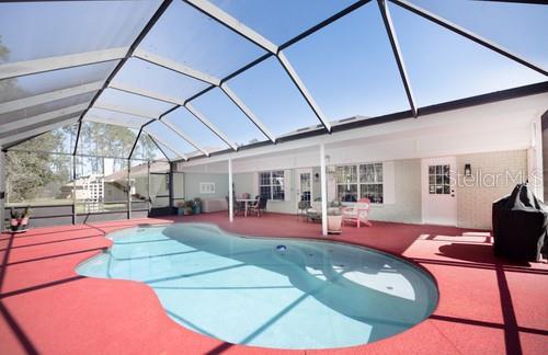 outdoor pool with a lanai and a patio area