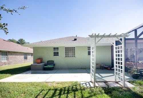 back of property with a patio area and a lawn