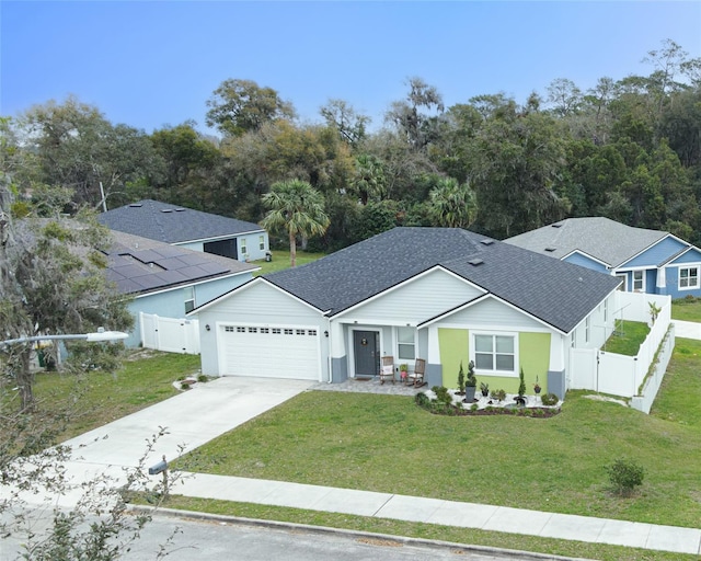 single story home with roof with shingles, fence, a garage, driveway, and a front lawn