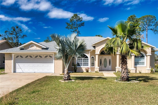 view of front facade with an attached garage, a front lawn, concrete driveway, and stucco siding