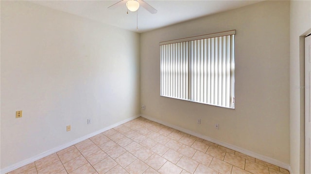 empty room featuring ceiling fan and baseboards