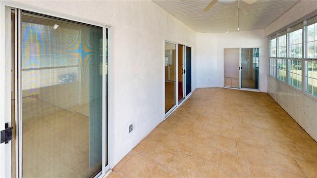 unfurnished sunroom featuring ceiling fan