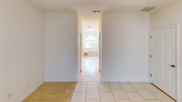 unfurnished room with visible vents, baseboards, and light tile patterned flooring