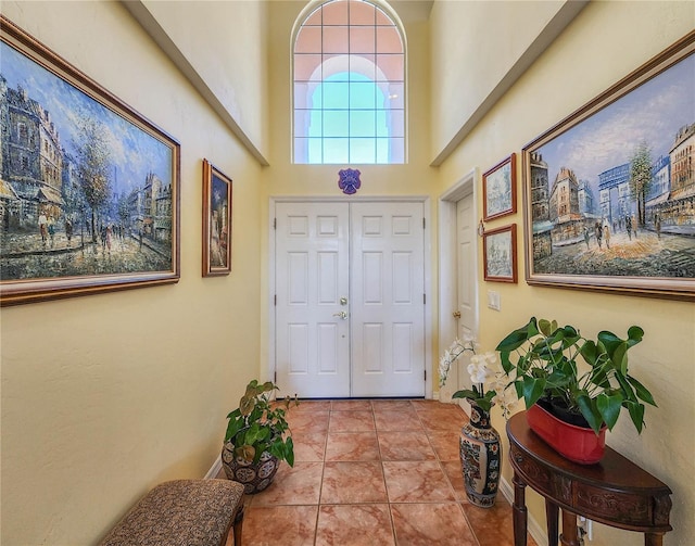 entryway with tile patterned flooring and a high ceiling