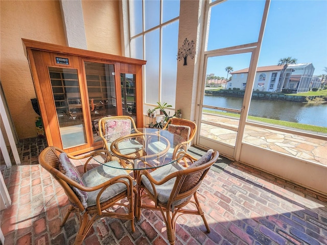 sunroom / solarium featuring a water view