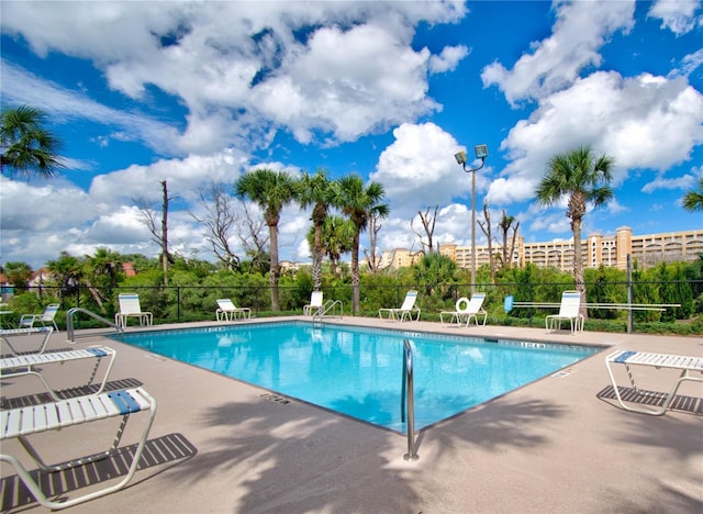 community pool with a patio and fence