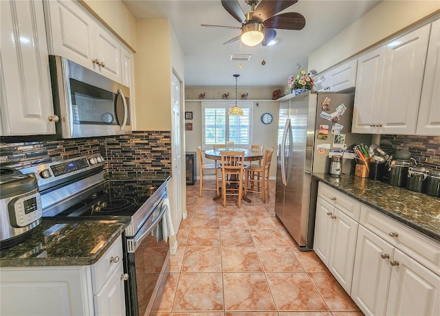 kitchen featuring tasteful backsplash, white cabinetry, stainless steel appliances, and light tile patterned flooring