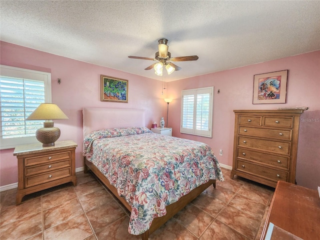 bedroom with a textured ceiling, multiple windows, and baseboards