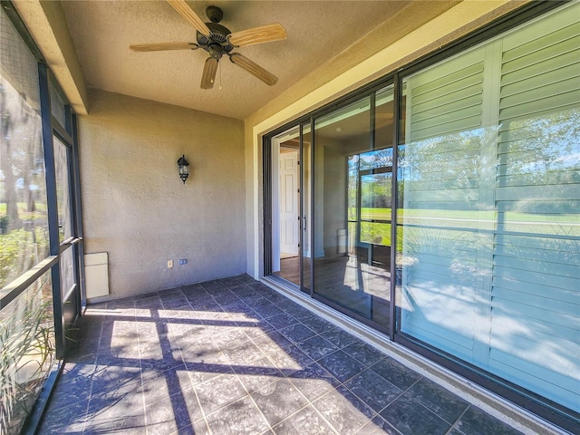 unfurnished sunroom with a ceiling fan