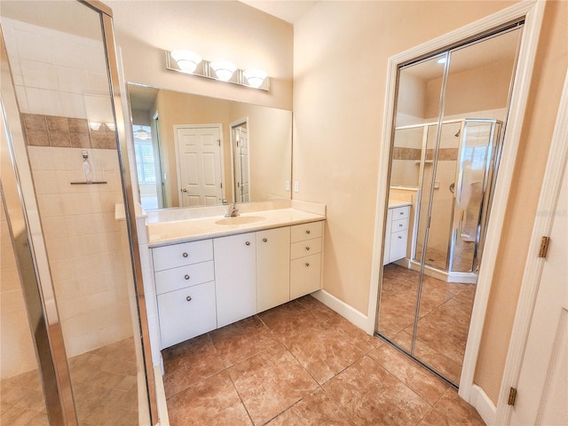 bathroom with a shower stall, baseboards, and vanity