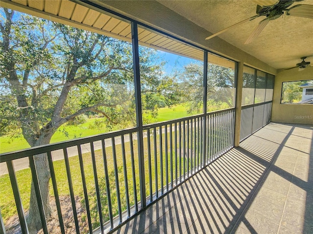 unfurnished sunroom featuring ceiling fan