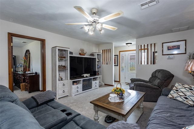 living room featuring a ceiling fan, visible vents, and light carpet