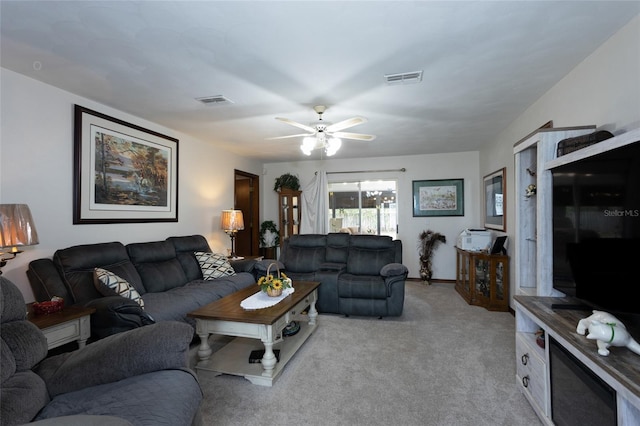 living area with visible vents, a ceiling fan, and light colored carpet