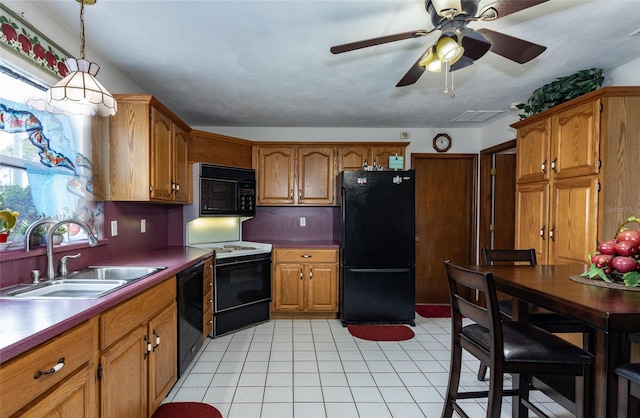 kitchen featuring brown cabinets, a sink, hanging light fixtures, and black appliances