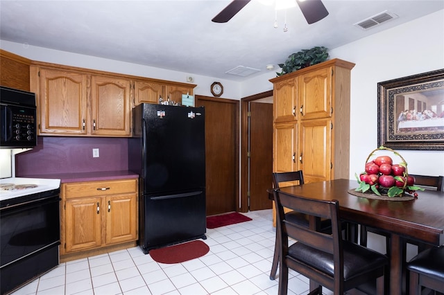 kitchen with brown cabinets, light tile patterned floors, visible vents, a ceiling fan, and black appliances