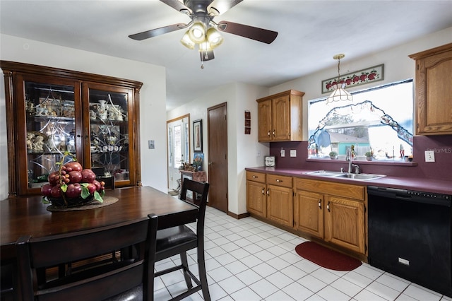 kitchen featuring dishwasher, brown cabinetry, a sink, and a wealth of natural light