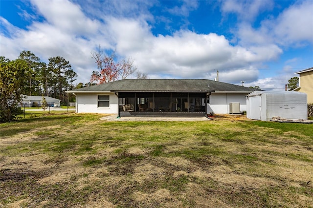 rear view of house with a storage shed, a lawn, a sunroom, fence, and central AC