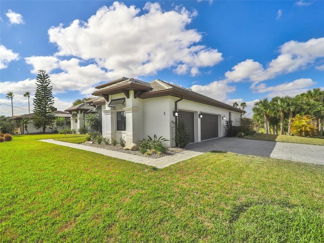 view of home's exterior featuring a garage, a yard, decorative driveway, and stucco siding