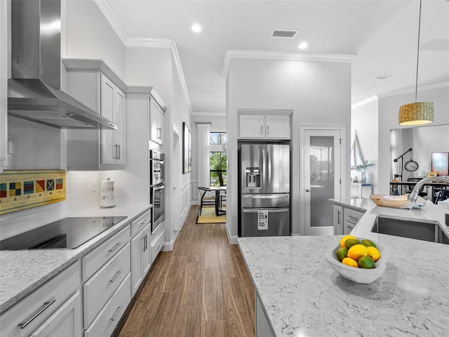 kitchen featuring stainless steel fridge with ice dispenser, wall chimney exhaust hood, light stone countertops, black electric stovetop, and a sink