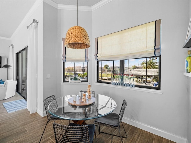 dining area featuring ornamental molding, baseboards, and wood finished floors