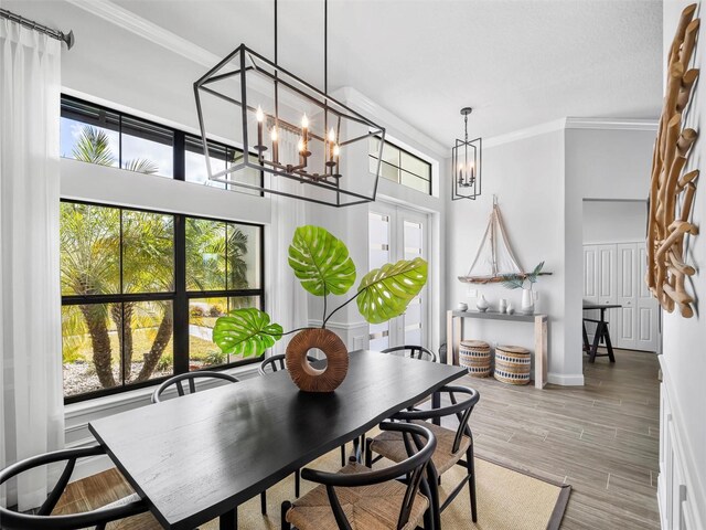 dining room with baseboards, crown molding, a chandelier, and wood finished floors