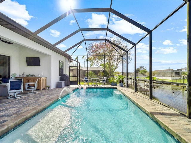 outdoor pool with a patio area, glass enclosure, and a bar