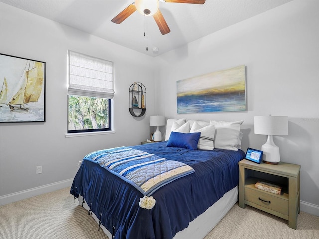 bedroom with light carpet, ceiling fan, and baseboards