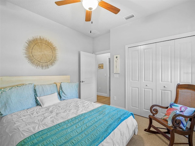 bedroom featuring ceiling fan, light carpet, visible vents, baseboards, and a closet