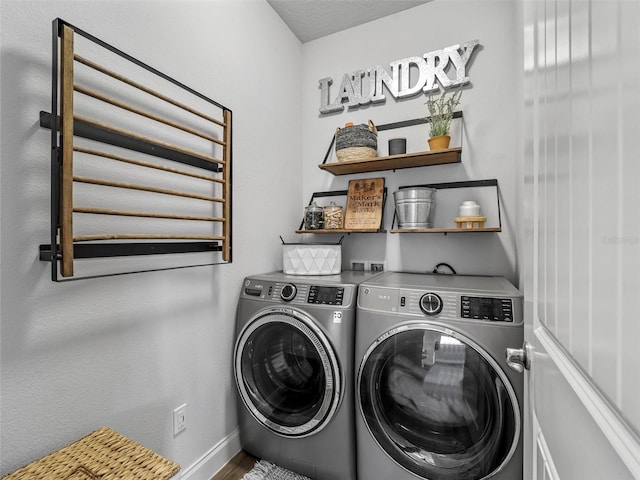 washroom featuring laundry area, baseboards, and washer and dryer