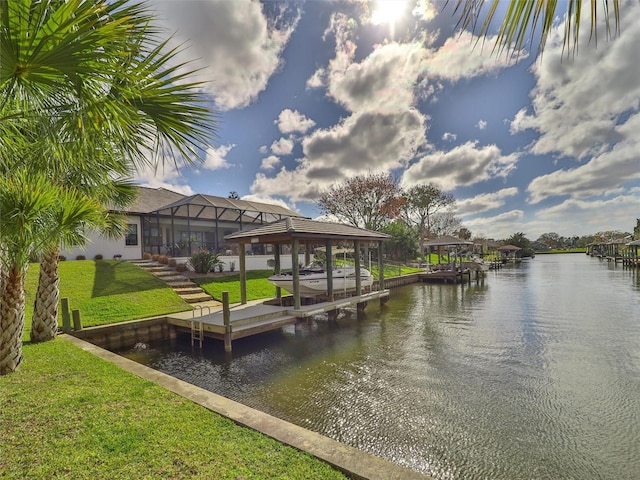 dock area featuring glass enclosure, a water view, a lawn, and boat lift