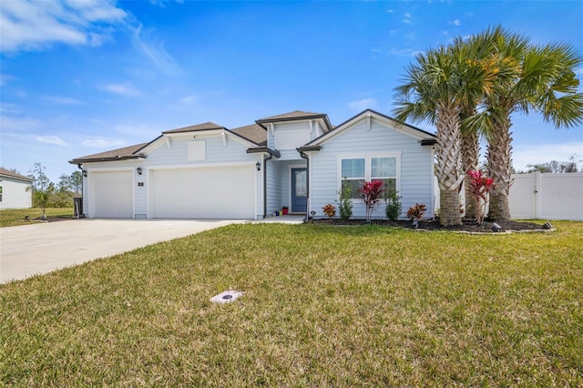 view of front facade with a front lawn, driveway, an attached garage, and fence