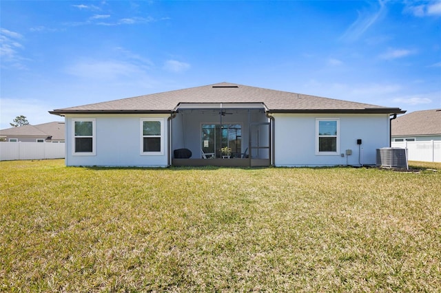 back of property featuring a sunroom, fence, a yard, central air condition unit, and stucco siding