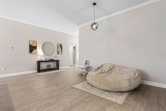 living area with crown molding, baseboards, lofted ceiling, and light wood-style floors