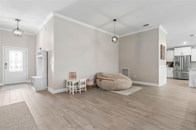 entrance foyer with light wood-type flooring, visible vents, and crown molding