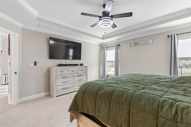 bedroom featuring baseboards, visible vents, light colored carpet, a tray ceiling, and crown molding