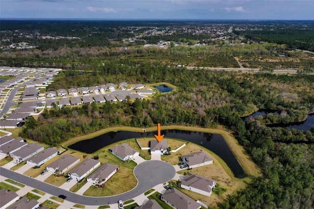 drone / aerial view with a residential view, a water view, and a view of trees