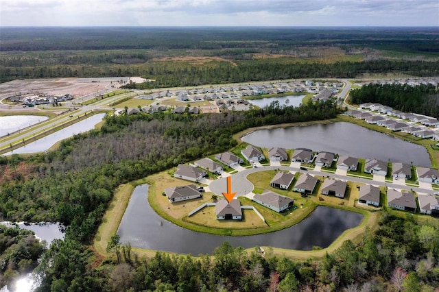 drone / aerial view featuring a water view, a residential view, and a wooded view