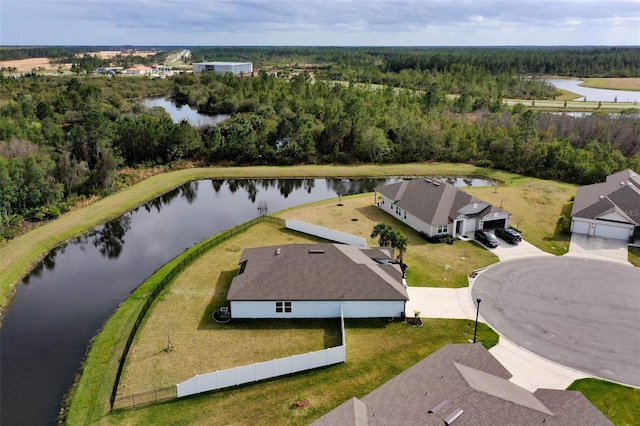 birds eye view of property featuring a water view and a wooded view