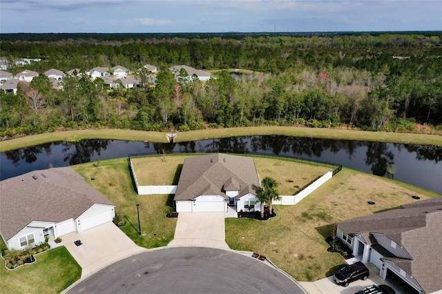 drone / aerial view with a water view, a residential view, and a view of trees