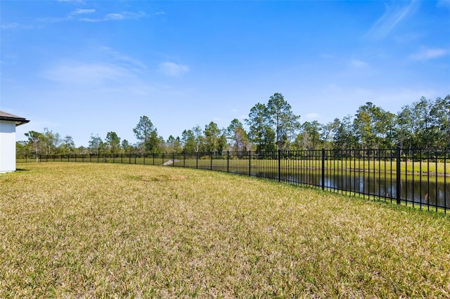 view of yard featuring a water view and fence