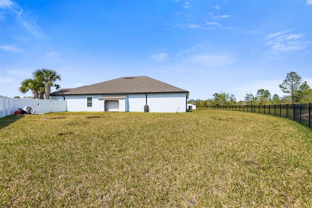 back of property with a fenced backyard and a yard